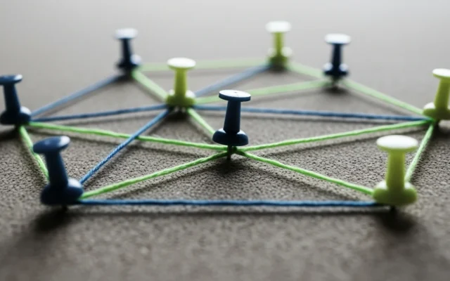 Pushpins connected by string on a corkboard, representing internal linking structure